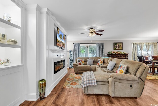 living room with ornamental molding, ceiling fan, and hardwood / wood-style flooring