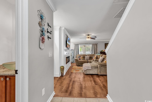 living room with ceiling fan, light hardwood / wood-style flooring, and ornamental molding