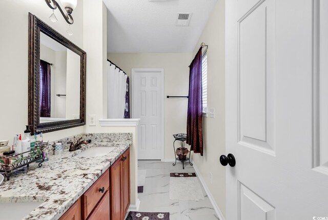 bathroom with a textured ceiling and vanity