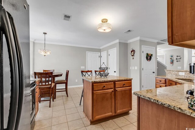 kitchen featuring hanging light fixtures, crown molding, light tile patterned floors, and stainless steel appliances