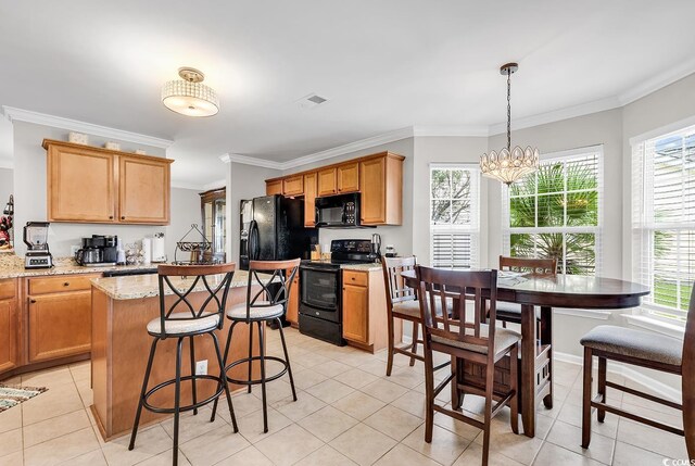 kitchen with light stone counters, a chandelier, black appliances, decorative light fixtures, and ornamental molding