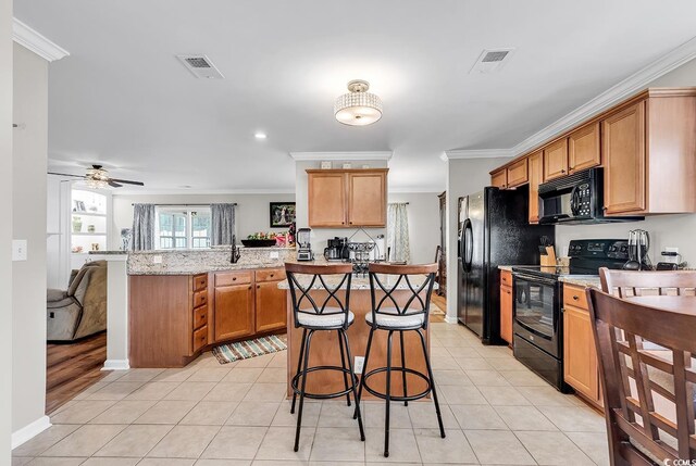 kitchen with ceiling fan, crown molding, light stone counters, and black appliances