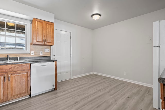 kitchen with white appliances, a sink, backsplash, and baseboards