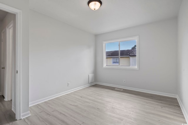 empty room featuring light wood-style flooring and baseboards