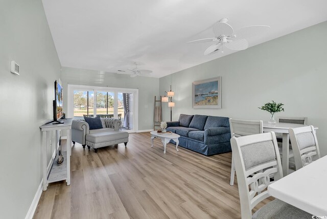 living room with ceiling fan and light hardwood / wood-style flooring