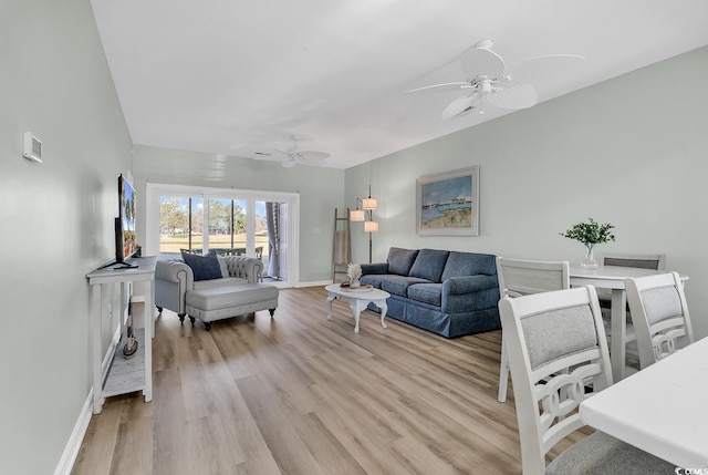 living area with ceiling fan, light wood-type flooring, and baseboards