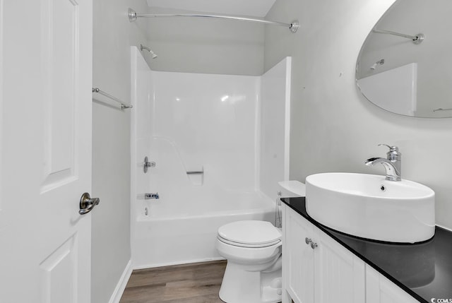 full bathroom with tub / shower combination, vanity, toilet, and hardwood / wood-style flooring