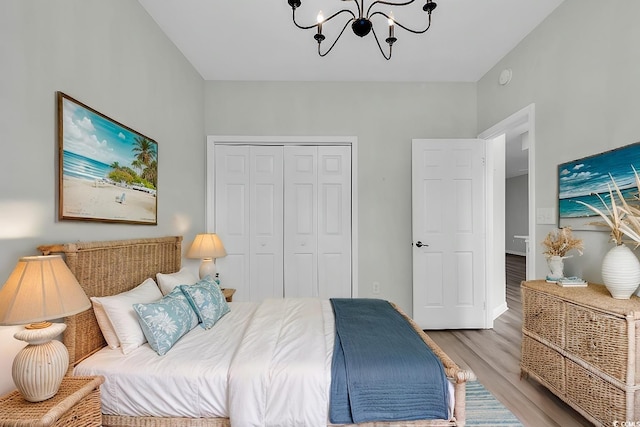 bedroom featuring light wood-type flooring, a chandelier, and a closet