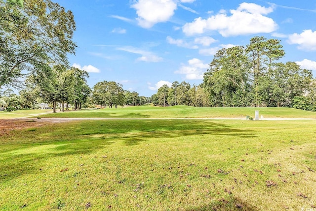 view of community with a lawn and golf course view