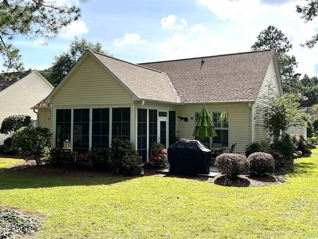 rear view of house with a sunroom and a yard