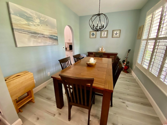 dining space featuring an inviting chandelier and light wood-type flooring