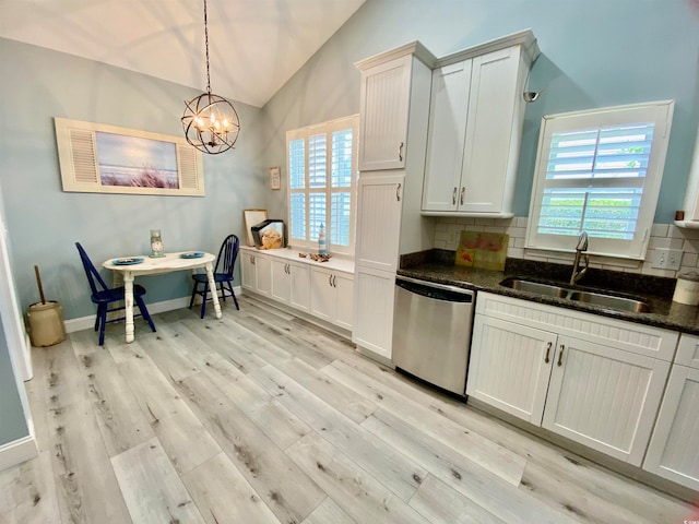 kitchen featuring sink, a notable chandelier, lofted ceiling, white cabinetry, and stainless steel dishwasher