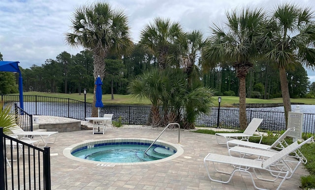 view of swimming pool featuring a yard, a community hot tub, a water view, and a patio area