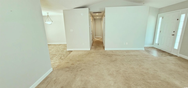 spare room with light colored carpet and lofted ceiling