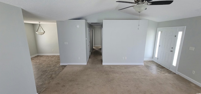 carpeted spare room with a textured ceiling, vaulted ceiling, and ceiling fan