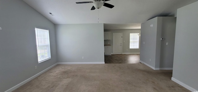 spare room with lofted ceiling, ceiling fan, and light colored carpet