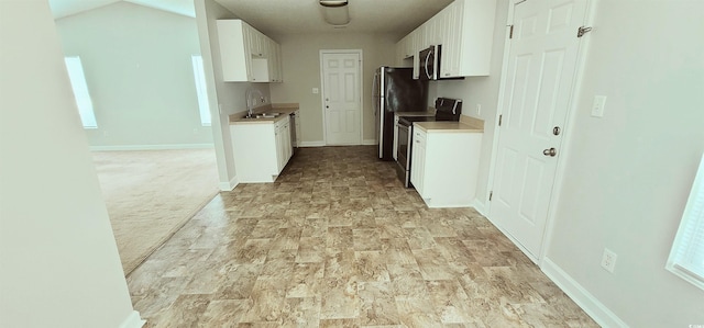 kitchen with white cabinetry, sink, light carpet, and stainless steel appliances