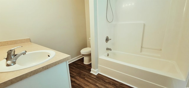 full bathroom with wood-type flooring, vanity, washtub / shower combination, and toilet