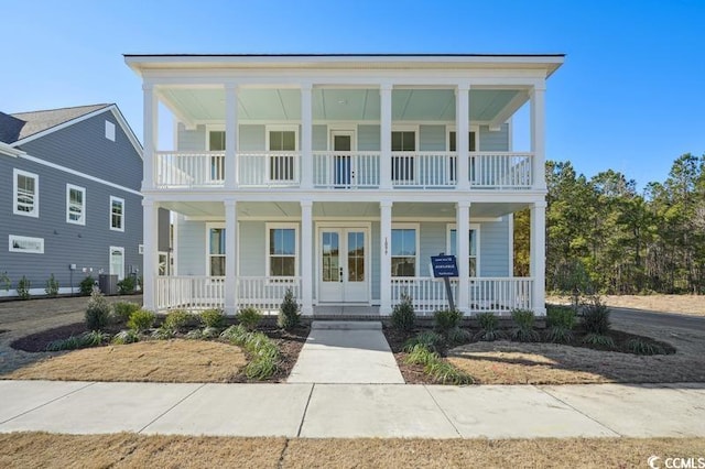 view of front facade with central air condition unit, covered porch, french doors, and a balcony