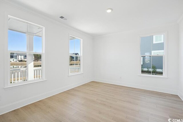 empty room featuring ornamental molding and light hardwood / wood-style floors