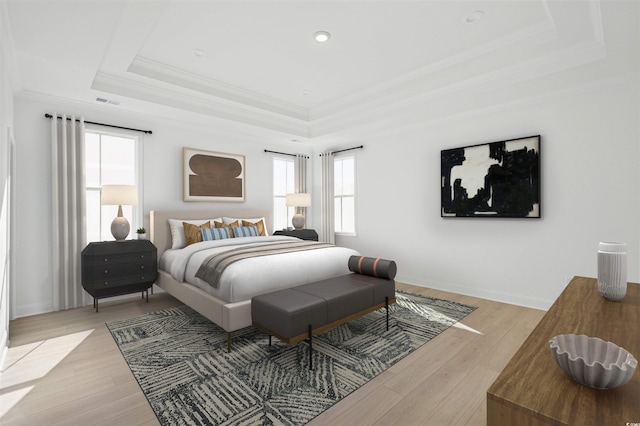 bedroom with light wood-type flooring, a raised ceiling, and ornamental molding
