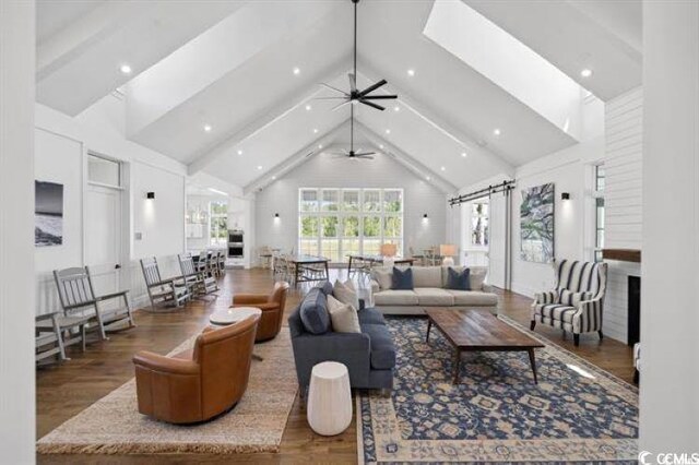 living room featuring hardwood / wood-style flooring, high vaulted ceiling, and beamed ceiling