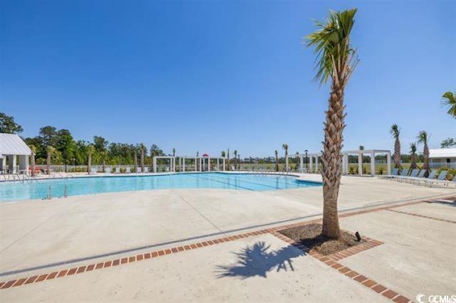 community pool with a patio area and a pergola