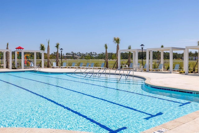 pool featuring a pergola, a patio, and fence