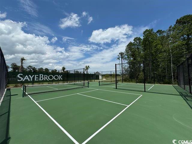 view of tennis court featuring community basketball court and fence