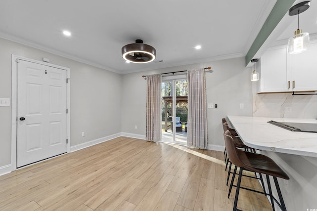 dining space featuring light hardwood / wood-style floors and crown molding