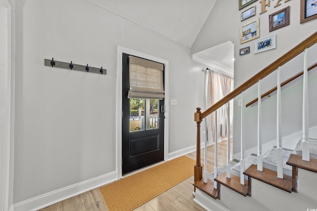 entrance foyer featuring vaulted ceiling and light hardwood / wood-style floors