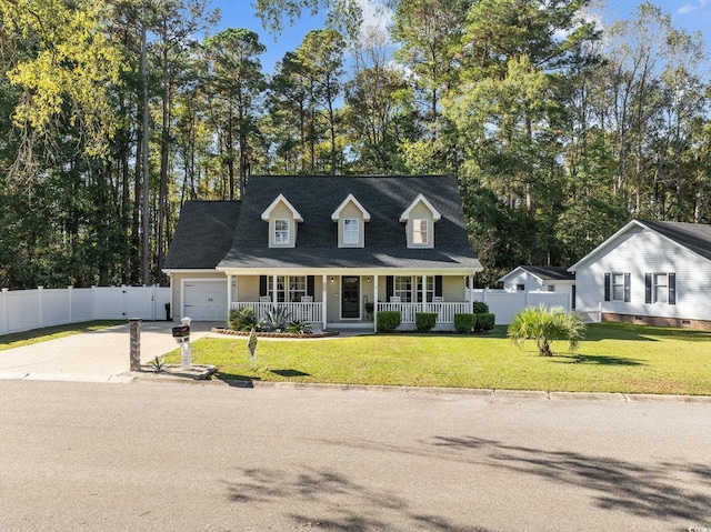 new england style home featuring covered porch, a front yard, and a garage