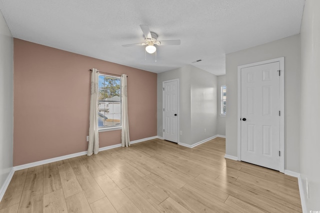 unfurnished room with ceiling fan, a textured ceiling, and light hardwood / wood-style flooring