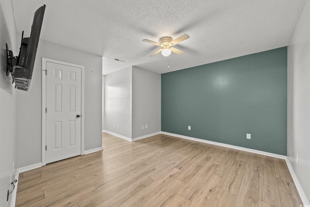 spare room featuring ceiling fan, a textured ceiling, and light hardwood / wood-style flooring