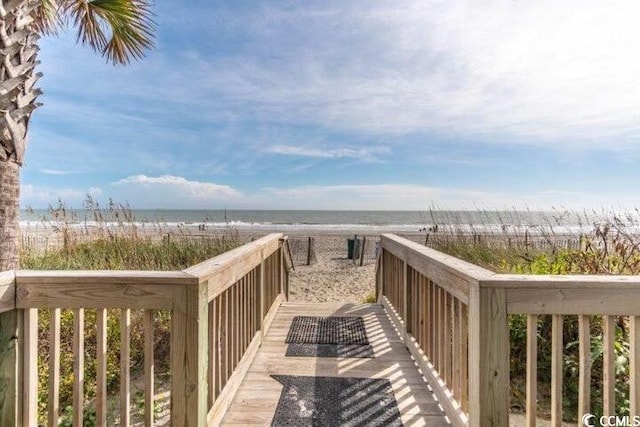 surrounding community featuring a water view and a beach view