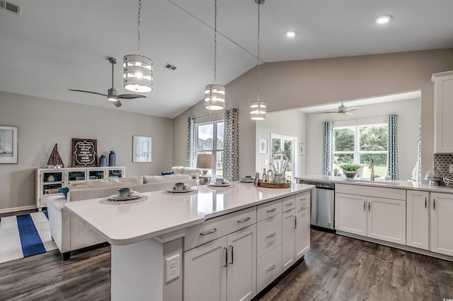 kitchen with dishwasher, white cabinets, vaulted ceiling, a kitchen island, and ceiling fan