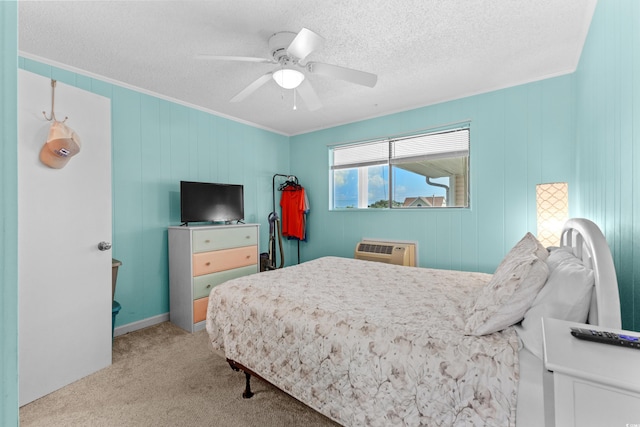 bedroom with a textured ceiling, crown molding, ceiling fan, light carpet, and a wall mounted air conditioner