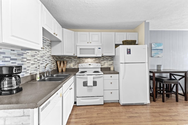 kitchen with light wood-type flooring, white appliances, and white cabinets