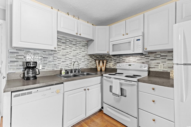 kitchen featuring white cabinets, sink, white appliances, a textured ceiling, and light hardwood / wood-style floors