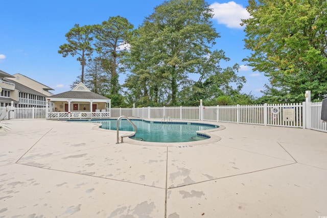 community pool featuring fence and a patio area