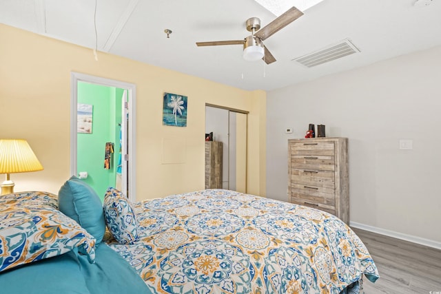 bedroom with ceiling fan, hardwood / wood-style flooring, and a closet