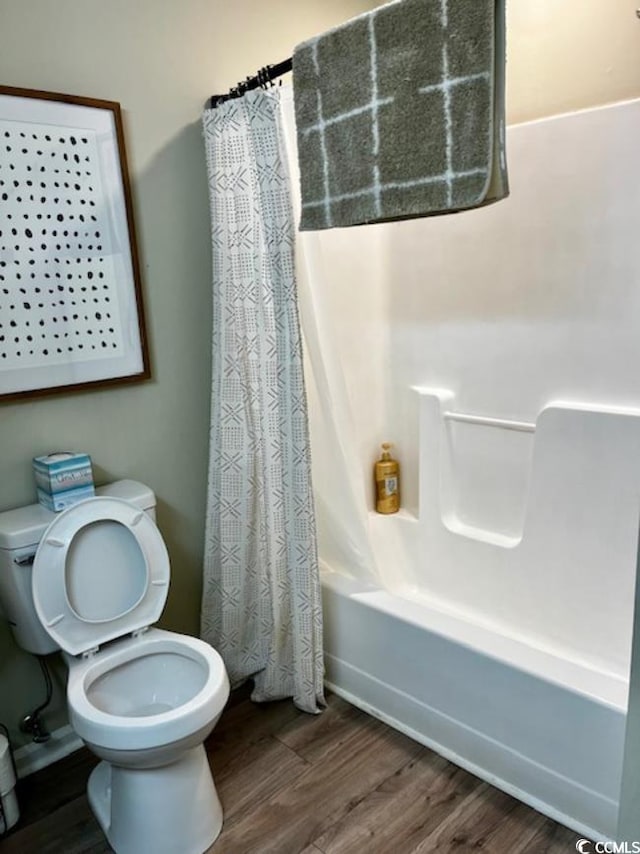 bathroom featuring hardwood / wood-style floors, toilet, and shower / tub combo with curtain