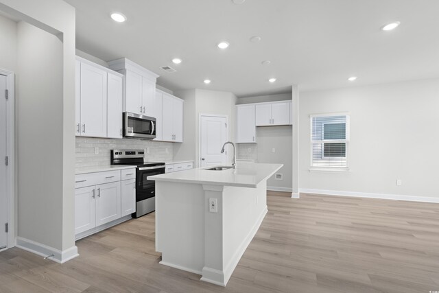 kitchen featuring white cabinetry, a kitchen island with sink, sink, and stainless steel appliances