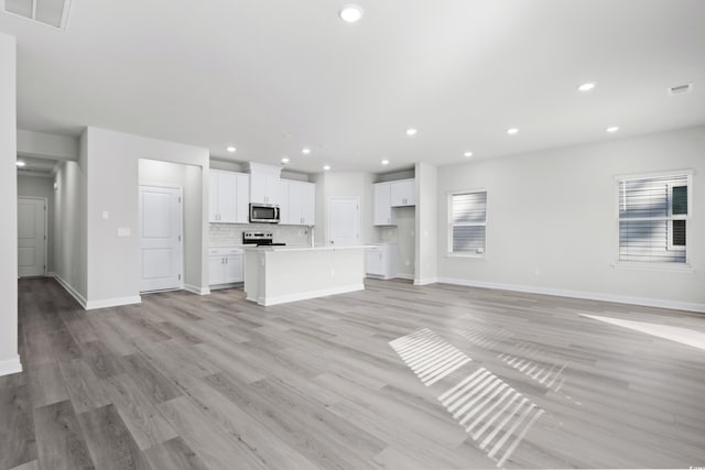623 Blackthorne Cir NW, Calabash, NC 28467 - unfurnished living room featuring light wood-type flooring and recessed lighting