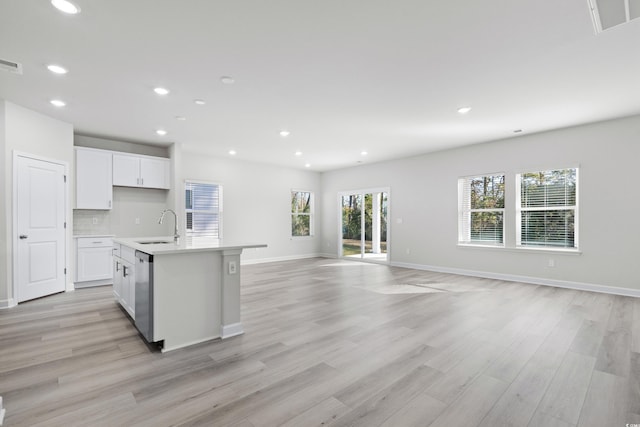 623 Blackthorne Cir NW, Calabash, NC 28467 - kitchen with dishwasher, white cabinets, light wood-style flooring, light countertops, and a center island with sink