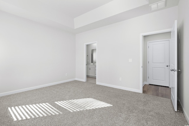 623 Blackthorne Cir NW, Calabash, NC 28467 - unfurnished bedroom with carpet, a raised ceiling, and ensuite bath