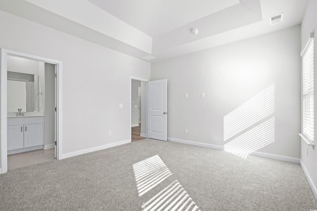 623 Blackthorne Cir NW, Calabash, NC 28467 - unfurnished bedroom featuring light carpet, a raised ceiling, and multiple windows