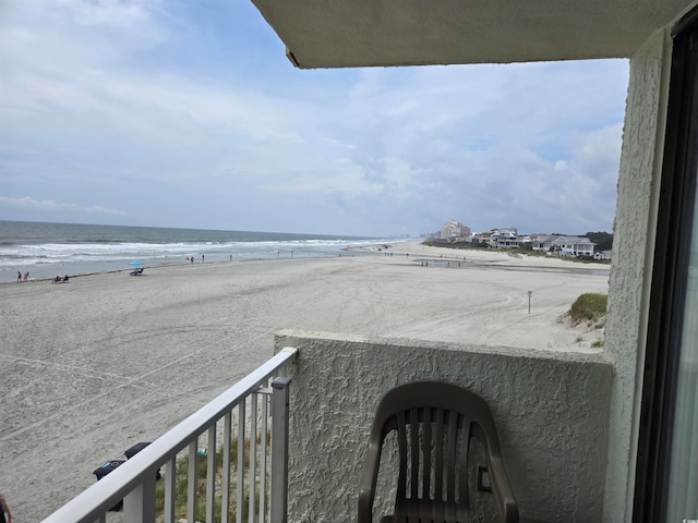 balcony featuring a view of the beach and a water view