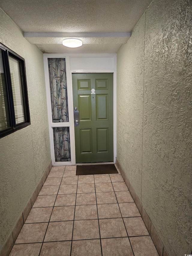 interior space featuring a textured ceiling and light tile patterned floors