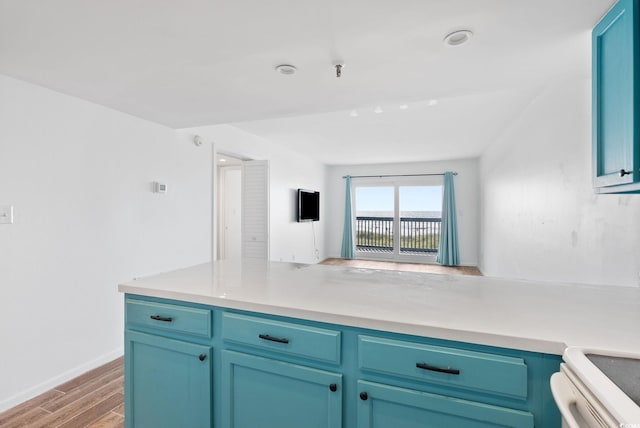 kitchen featuring stove, blue cabinets, and light hardwood / wood-style floors